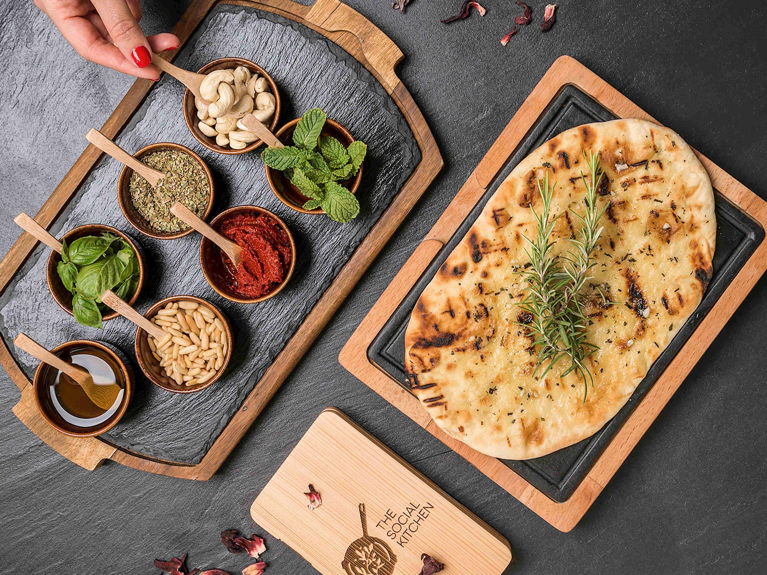 The Retreat Palm Dubai Mgallery By Sofitel Esterno foto The photo displays a beautifully arranged food presentation featuring various ingredients and a piece of flatbread. On the left, there are small bowls containing spices, herbs, and nuts, including cashews, mint leaves, and possibly different spice po