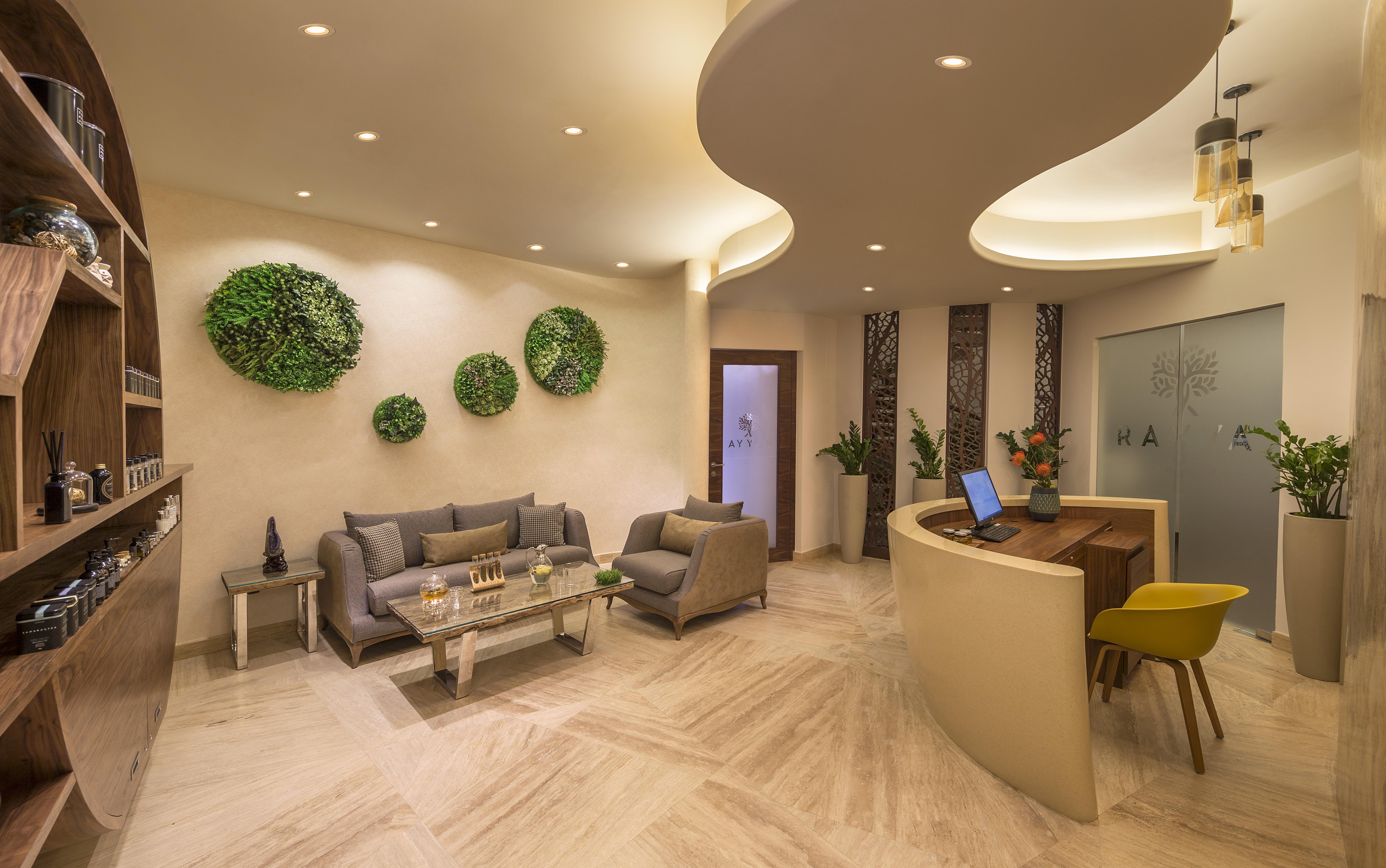 The Retreat Palm Dubai Mgallery By Sofitel Esterno foto The photo shows a modern and stylish reception area. The space features two gray sofas arranged around a glass coffee table. The walls are adorned with green circular decorative elements, and there are plants present, adding a touch of nature to the 